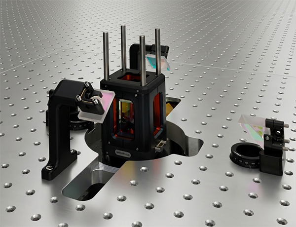 A close up shot of the RuBECi system mounted on an optical breadboard, with optical lenses and mirrors for quantum experimentation.