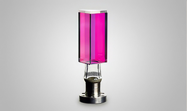 A glass prism with metal flange, illuminated in pink from AR coating.