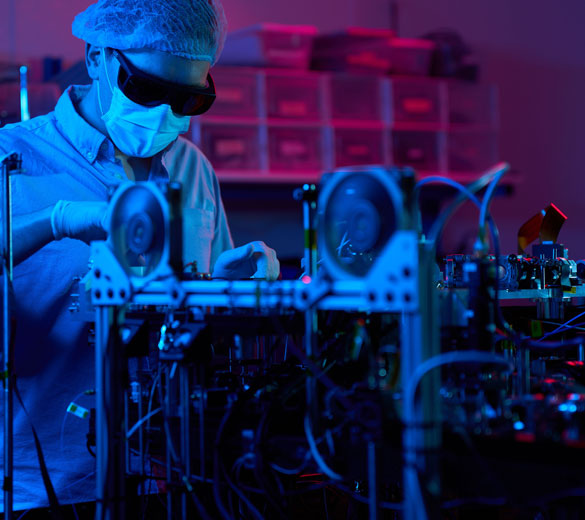 A quantum physicist in protective clothing and goggles works on Infleqtion's Sqale quantum computer QPU.